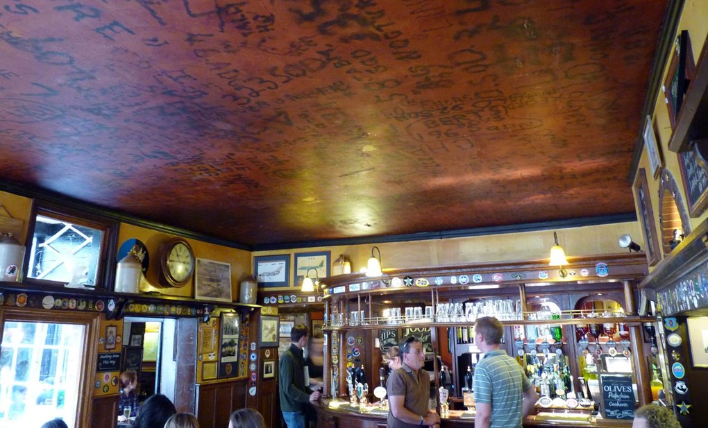 "The RAF Bar ceiling with graffiti of World War II airmen" by Cmglee CC BY 3.0
